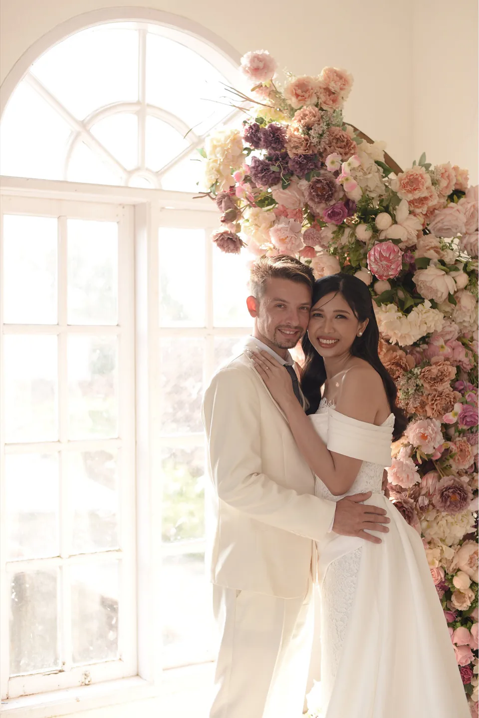 Photo de pré-mariage de Luci et Adrien devant une composition florale